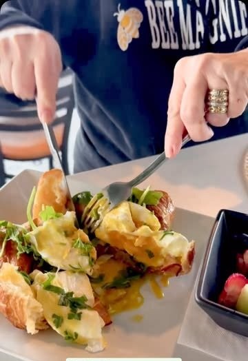 Cutting into a fresh eggs Benedict, steam rising