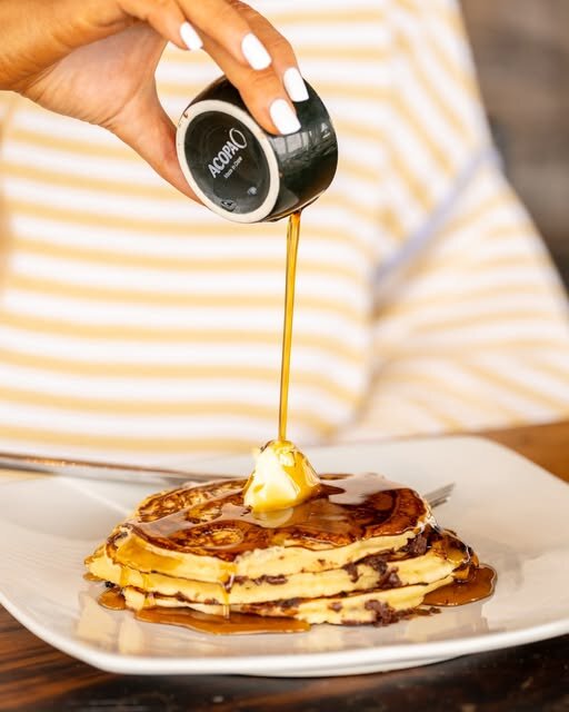Warm syrup poured over pancakes