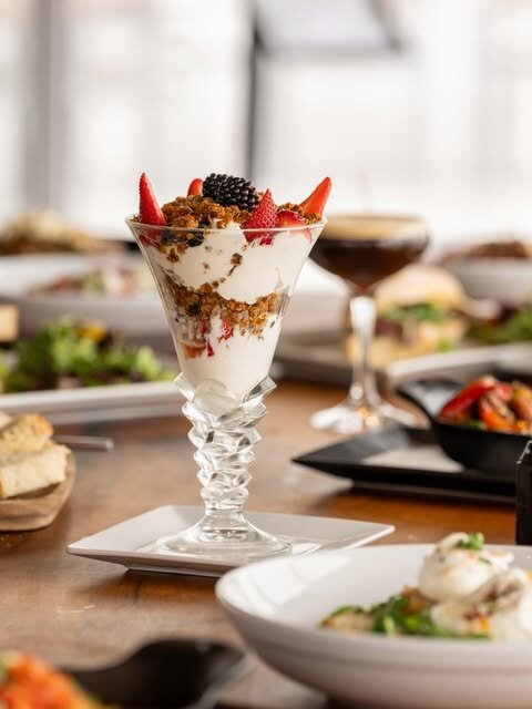 Berry parfait and brunch plates on the table